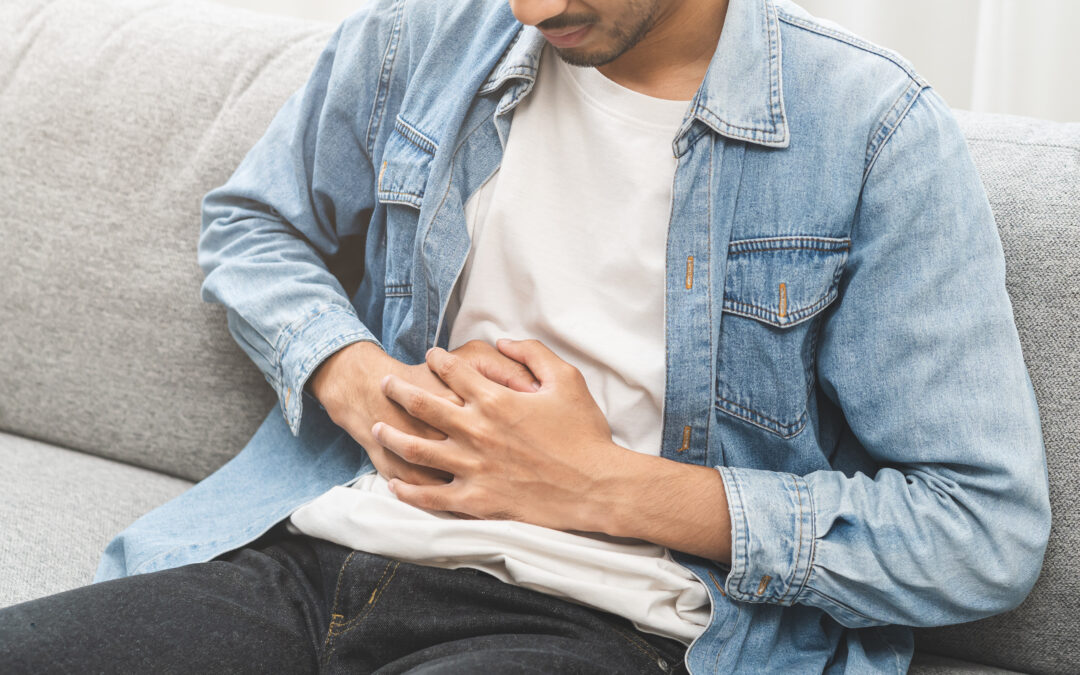 Man holding his stomach because he is sick from food poisoning.